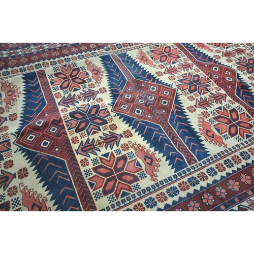1275 - A GEOMETRIC WOOLLEN RUG, with repeating pattern, on a cream field, and a multi strap border, 298cm x... 