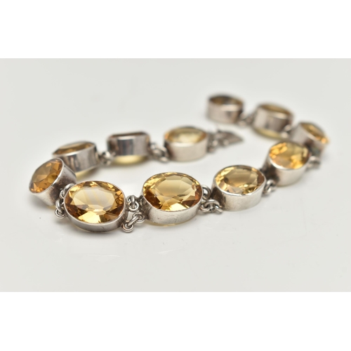 20 - A WHITE METAL CITRINE LINE BRACELET, designed as a series of slightly graduated, oval cut citrines, ... 