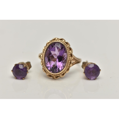 31 - A 9CT GOLD AMETHYST RING AND A PAIR OF AMETHYST EARRINGS, the ring of an oval form set with an oval ... 