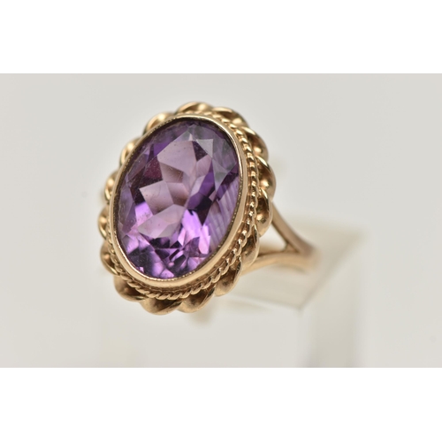 31 - A 9CT GOLD AMETHYST RING AND A PAIR OF AMETHYST EARRINGS, the ring of an oval form set with an oval ... 