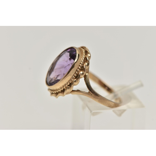 31 - A 9CT GOLD AMETHYST RING AND A PAIR OF AMETHYST EARRINGS, the ring of an oval form set with an oval ... 