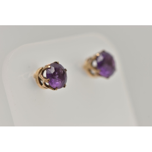 31 - A 9CT GOLD AMETHYST RING AND A PAIR OF AMETHYST EARRINGS, the ring of an oval form set with an oval ... 