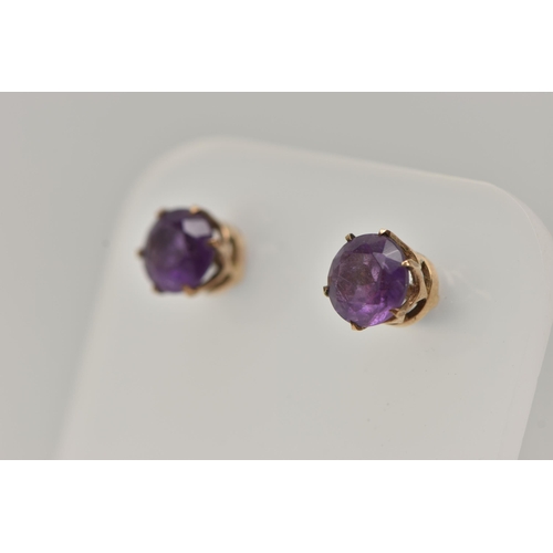 31 - A 9CT GOLD AMETHYST RING AND A PAIR OF AMETHYST EARRINGS, the ring of an oval form set with an oval ... 