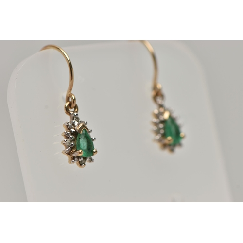 32 - A PAIR OF EMERALD DROP EARRINGS, each earring set with a pear cut emerald, within a surround of smal... 