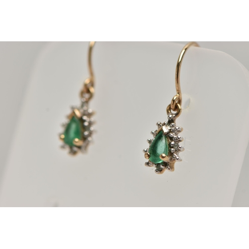 32 - A PAIR OF EMERALD DROP EARRINGS, each earring set with a pear cut emerald, within a surround of smal... 