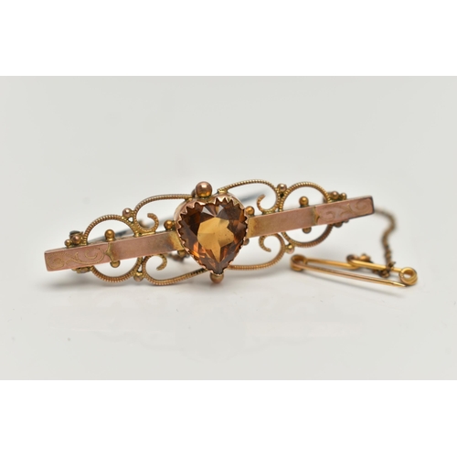 38 - A YELLOW METAL SWEETHEART BROOCH, set with a central heart cut citrine, to a polished bar with flora... 