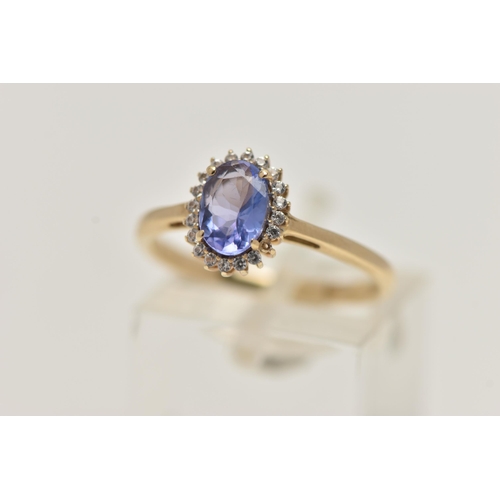 9 - A 9CT GOLD GEM CLUSTER RING, designed as a central oval tanzanite within a circular cut colourless g... 