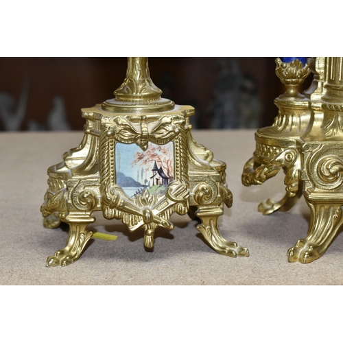 416 - A 20TH CENTURY BRASS AND PORCELAIN CLOCK GARNITURE, the porcelain panels transfer printed with coupl... 