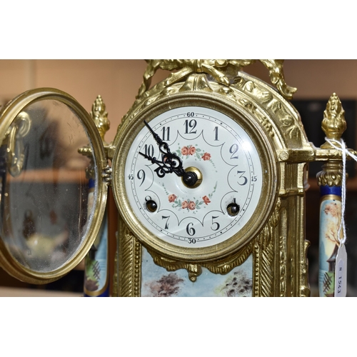 416 - A 20TH CENTURY BRASS AND PORCELAIN CLOCK GARNITURE, the porcelain panels transfer printed with coupl... 