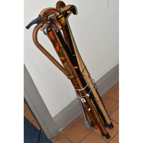 565 - A GROUP OF ELEVEN WALKING STICKS, comprising a right handed stick with a handle for arthritis suffer... 