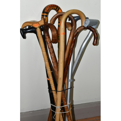 565 - A GROUP OF ELEVEN WALKING STICKS, comprising a right handed stick with a handle for arthritis suffer... 