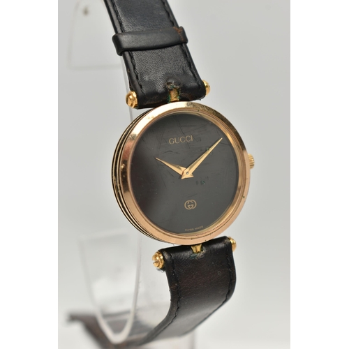 15 - A VINTAGE LADYS GOLD PLATED QUARTZ GUCCI WRISTWATCH, round black dial signed Gucci, case width appro... 