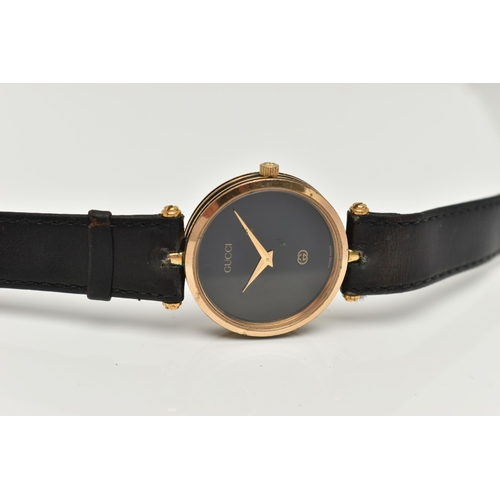 15 - A VINTAGE LADYS GOLD PLATED QUARTZ GUCCI WRISTWATCH, round black dial signed Gucci, case width appro... 