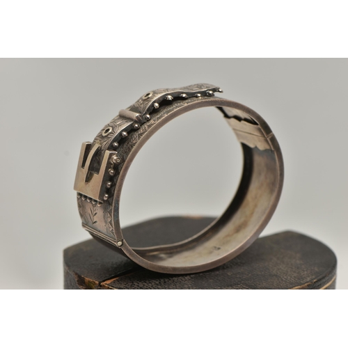 38 - A LATE VICTORIAN SILVER HINGED BANGLE, of a belt and buckle design, floral detail with applied bead ... 