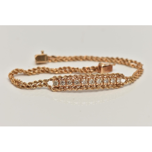 80 - A YELLOW METAL DIAMOND BRACELET, centring on a row of ten round brilliant cut diamonds, estimated to... 