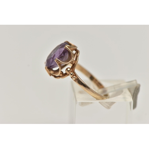 96 - A 9CT GOLD AMETHYST RING, an oval cut amethyst prong set in a yellow gold scalloped mount, hallmarke... 