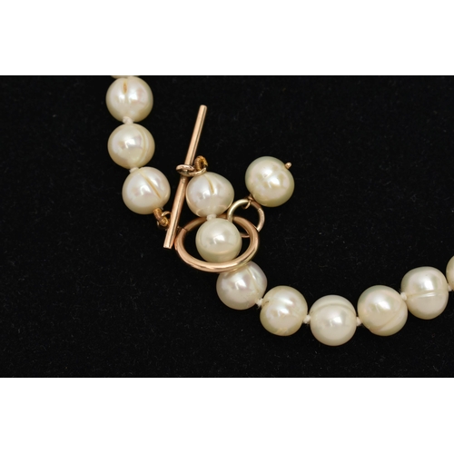 142 - A CULTURED PEARL NECKLACE, a string of baroque cultured pearls, fitted with a yellow gold toggle cla... 