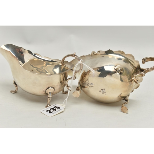 235 - A PAIR OF GEORGE V SILVER SAUCEBOATS, of oval form with wavy rims, S scroll handles, on three cabrio... 