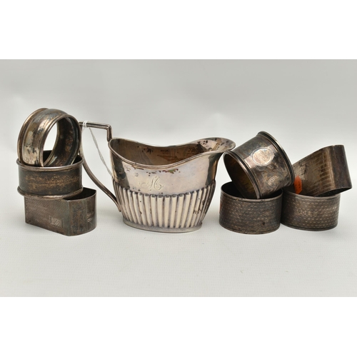 240 - A LATE VICTORIAN SILVER CREAM JUG AND SEVEN ASSORTED SILVER NAPKIN RINGS, the oval cream jug with st... 