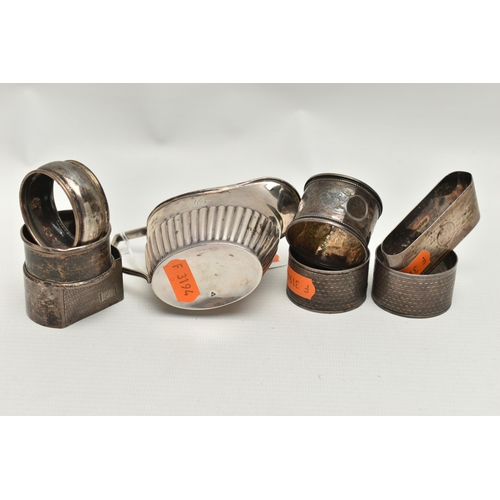 240 - A LATE VICTORIAN SILVER CREAM JUG AND SEVEN ASSORTED SILVER NAPKIN RINGS, the oval cream jug with st... 