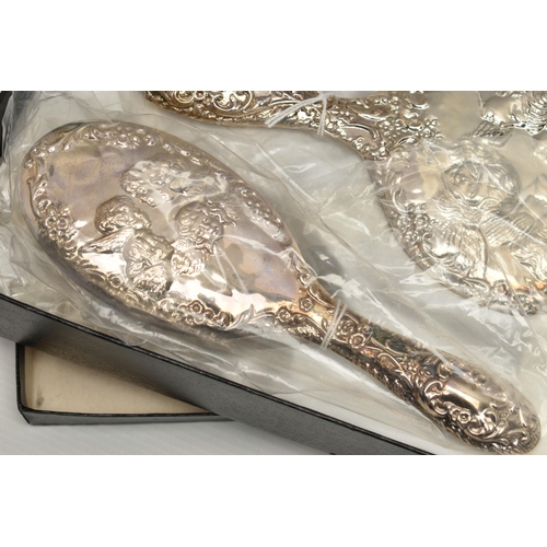 246 - A BOXED ELIZABETH II SILVER MOUNTED FOUR PIECE DRESSING TABLE SET, repoussé decorated with Reynolds ... 