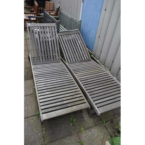 1001 - A PAIR OF TEAK SLATTED GARDEN LOUNGERS, length 194cm (condition - one with bolt missing to the recli... 