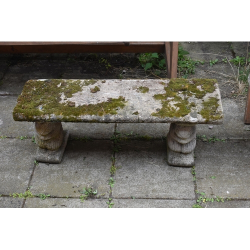 1023 - A WEATHERED COMPOSITE GARDEN BENCH, with a rectangular top, resting on twin pedestals depicting squi... 