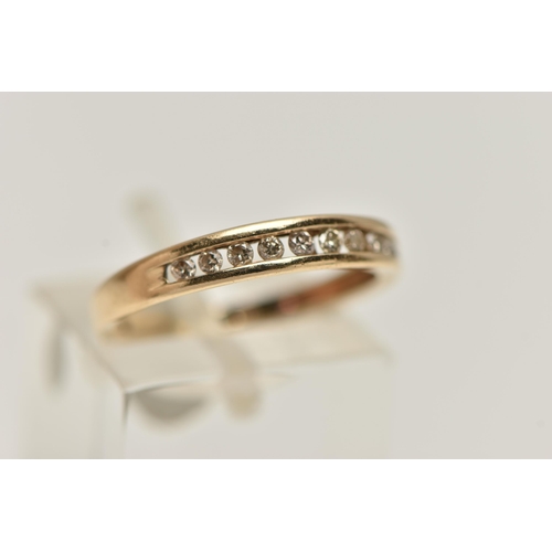 16 - A YELLOW METAL DIAMOND HALF ETERNITY RING, designed as a row of ten channel set, round brilliant cut... 