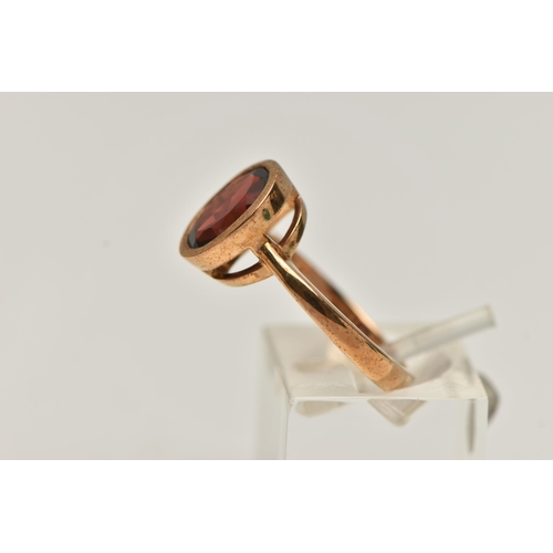 17 - A 9CT GOLD GARNET RING, oval cut garnet in a collet setting, mount measuring approximately length 11... 