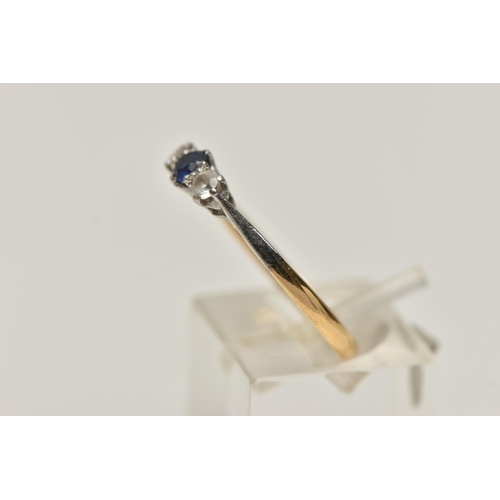 39 - A YELLOW METAL THREE STONE RING, set with a central circular cut blue sapphire, flanked with circula... 