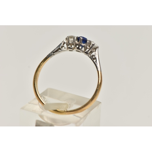 39 - A YELLOW METAL THREE STONE RING, set with a central circular cut blue sapphire, flanked with circula... 