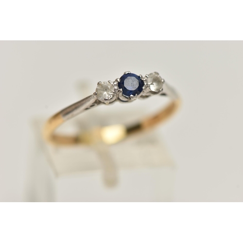 39 - A YELLOW METAL THREE STONE RING, set with a central circular cut blue sapphire, flanked with circula... 