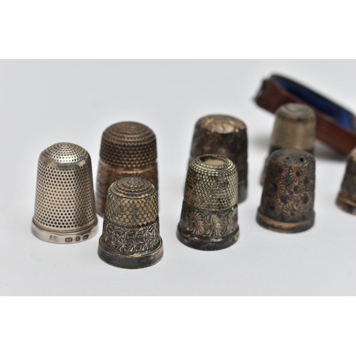 82 - A LATE VICTORIAN WOODEN CASED SILVER THIMBLE AND EIGHT OTHER SILVER / WHITE METAL THIMBLES,  the cas... 