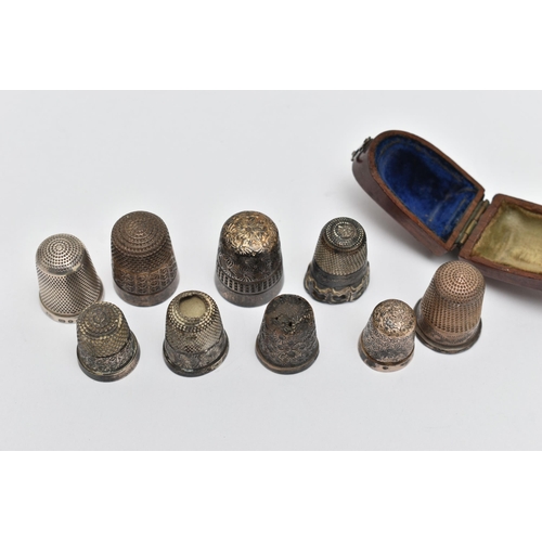 82 - A LATE VICTORIAN WOODEN CASED SILVER THIMBLE AND EIGHT OTHER SILVER / WHITE METAL THIMBLES,  the cas... 