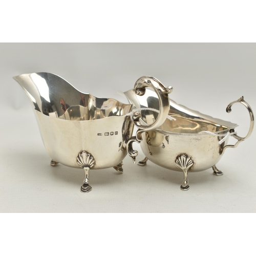 94 - TWO GEORGE VI SILVER SAUCE BOATS, both with wavy rims, C scroll handles and on three cabriole legs w... 