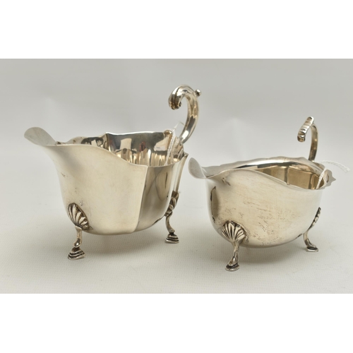 94 - TWO GEORGE VI SILVER SAUCE BOATS, both with wavy rims, C scroll handles and on three cabriole legs w... 