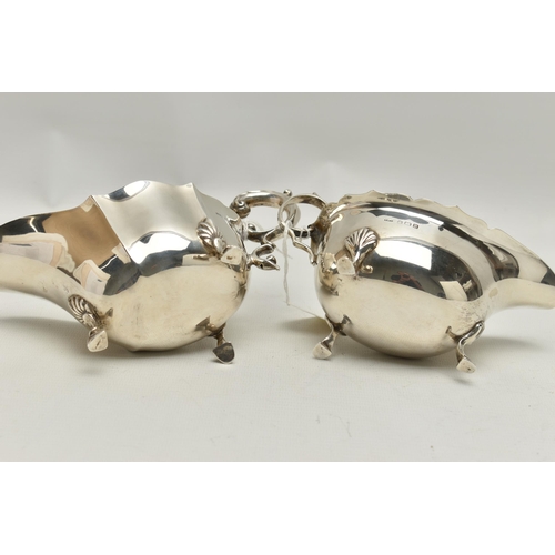 94 - TWO GEORGE VI SILVER SAUCE BOATS, both with wavy rims, C scroll handles and on three cabriole legs w... 