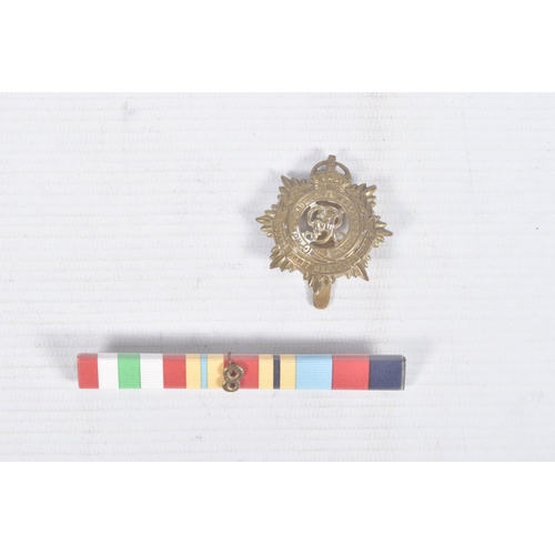 285 - A TIN CONTAINING FOUR WWII MEDALS, a ribbon bar and a cap badge, the medals are all un-named and con... 