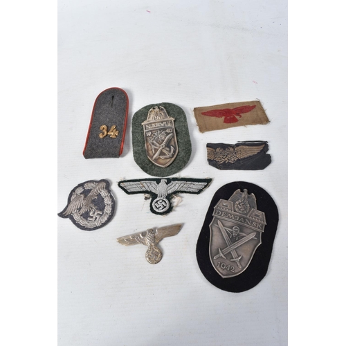 342 - A SMALL COLLECTION OF GERMANY UNIFORM ITEMS, these include a Narvik shield, Demjansk shield, a cloth... 