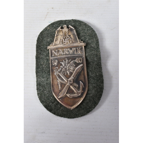 342 - A SMALL COLLECTION OF GERMANY UNIFORM ITEMS, these include a Narvik shield, Demjansk shield, a cloth... 