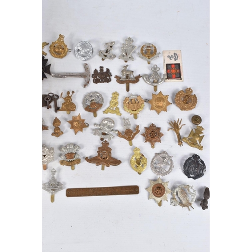 354 - A BOX CONTAINING OVER THIRTY FIVE CAP BADGES, and an assortment soft back magazines relating to WWII... 