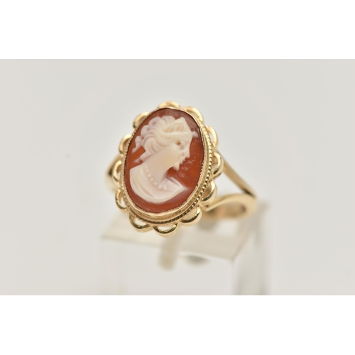 12 - A 9CT GOLD CAMEO RING, carved shell cameo, collet set within a fine rope twist and scallop surround,... 