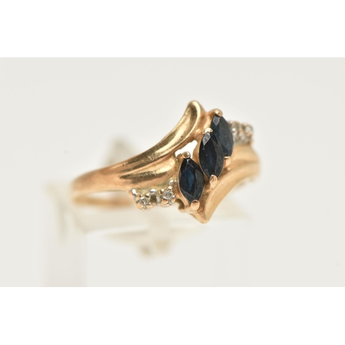 58 - A YELLOW METAL GEM SET RING, asymmetrical design set with three marquise cut blue sapphires, and fou... 