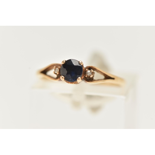 59 - A YELLOW METAL SAPPHIRE AND DIAMOND RING, set with a central circular cut deep blue sapphire, flanke... 