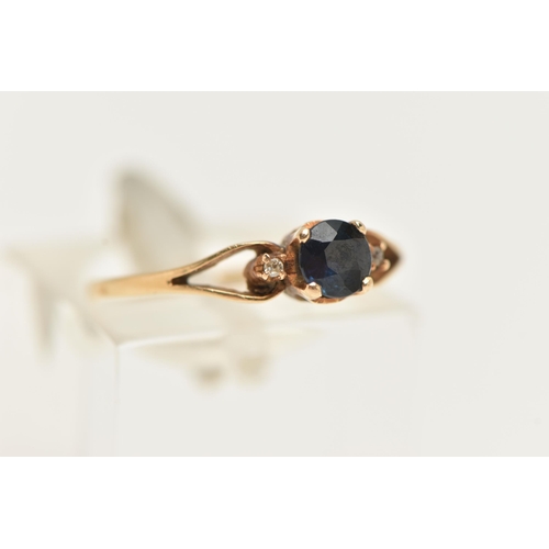 59 - A YELLOW METAL SAPPHIRE AND DIAMOND RING, set with a central circular cut deep blue sapphire, flanke... 