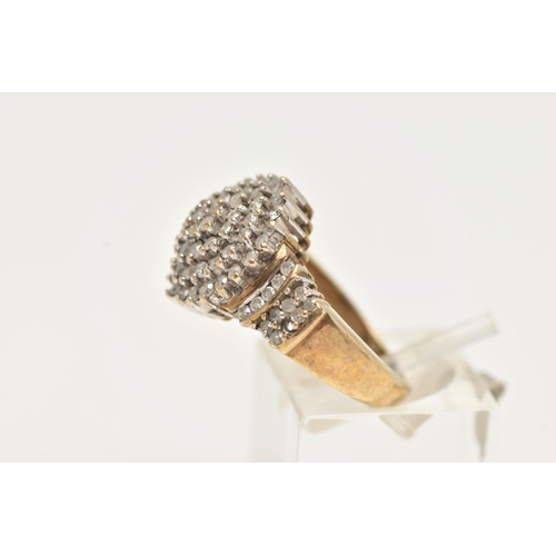 63 - A DIAMOND CLUSTER RING, a yellow metal diamond cluster ring, tapered shoulders to a plain polished b... 