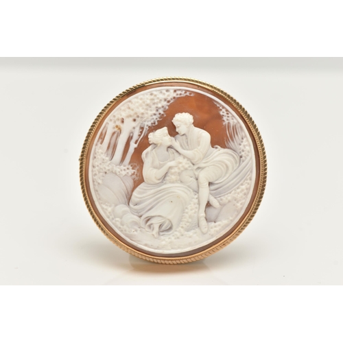 69 - A 9CT GOLD CAMEO BROOCH, of a circular form, carved shell cameo depicting a couple scene, collet set... 