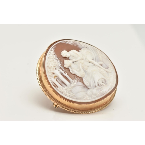 69 - A 9CT GOLD CAMEO BROOCH, of a circular form, carved shell cameo depicting a couple scene, collet set... 