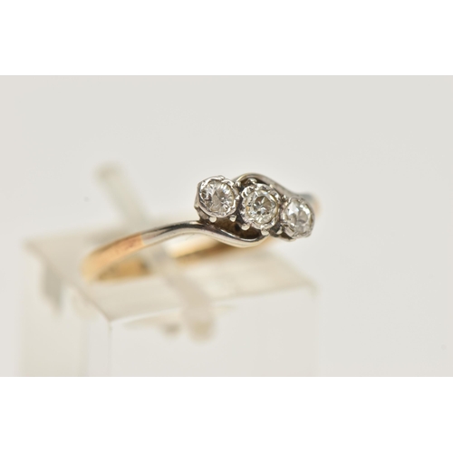 73 - A YELLOW METAL THREE STONE DIAMOND RING, asymmetrical row of three old cut diamonds, white metal mou... 