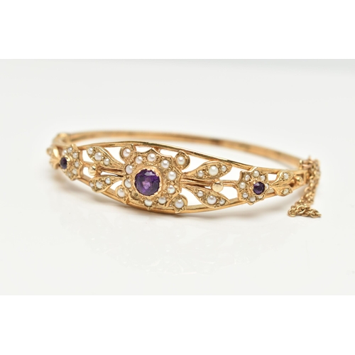 75 - A 9CT GOLD AMETHYST AND SEED PEARL HINGED BANGLE, floral pattern bangle set with three circular cut ... 